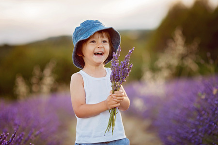 Little fashionable boy having fun in lavender field の写真素材