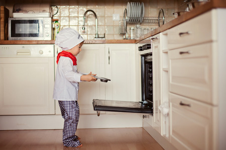 Little boy, baking muffins in the kitchenの写真素材
