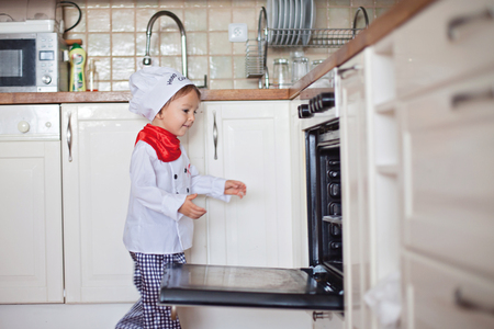 Little boy, baking muffins in the kitchenの写真素材