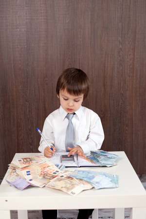 Young man, counting money and taking notesの写真素材