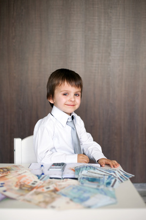 Young man, counting money and taking notesの写真素材