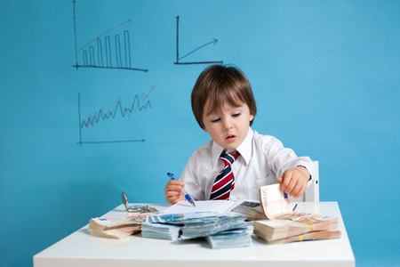 Young boy, counting money and taking notesの写真素材