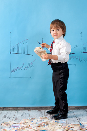 Little boy with a stack of moneyの写真素材