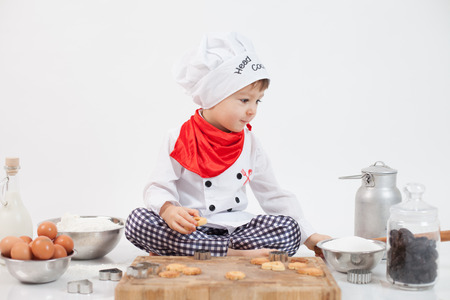 Little boy with chefs hat, preparing cookiesの写真素材