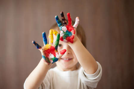Happy kid with paints on hands 