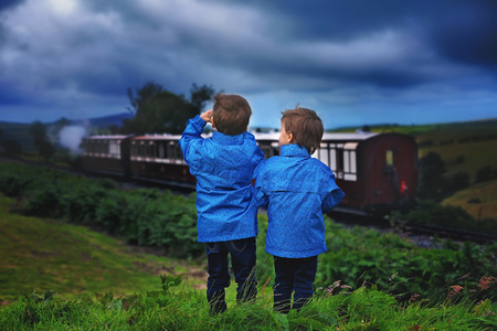 Two boy, looking at old steam train, outdoor