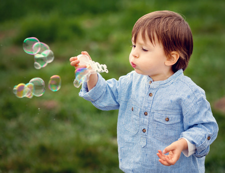 Little boy blowing soap bubbles, closeup portraitの写真素材