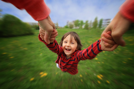 Mother, spinning in circle her little baby boy, pure joy, radial blur, springtime, daytimeの写真素材