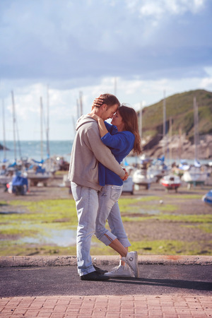 Young attractive couple in love , love story, standing on a harbor, kissingの写真素材