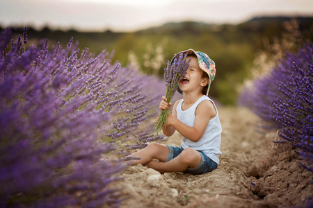 Little fashionable boy having fun in lavender fieldの写真素材