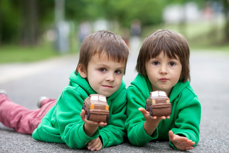 Funny little boys playing with car of chocolate, outdoor, having funの写真素材