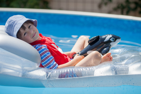 Sweet little boy, swimming in big swimming pool, summertimeの写真素材