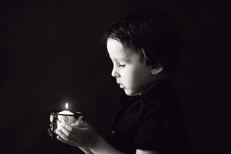 Little boy praying, child praying, isolated black backgroundの写真素材