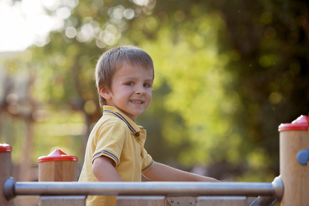 Cute child, boy, having fun on the playground, active kid climbing and playing. Active and happy childhoodの写真素材