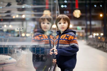 Cute boy, watching some toys at the airport, while waiting for his plane to departure, Christmas...