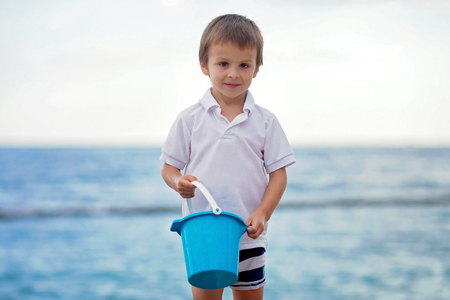 Cute little preschooler boy, playing in the sand on the beach with beach toys, Monaco beach, Europeの写真素材