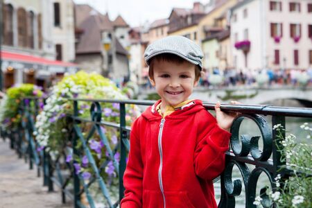 Sweet portrait of preschool boy in the town of Annecy, France, springtime, enjoying the view of the channelの写真素材