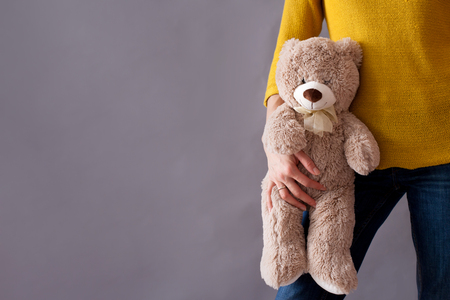 Young girl, holding sweet fluffy teddy bear, isolated imageの写真素材