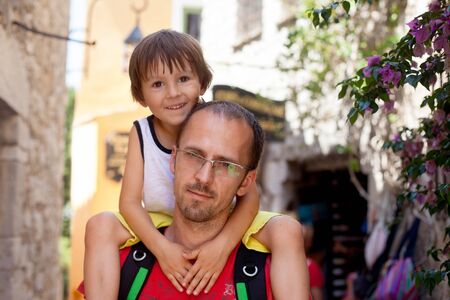 Young father, carrying his toddler boy on his neck, summertime, child smiling. Fathers day conceptの写真素材