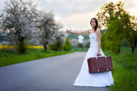 Young bride on the road with a suitcaseの写真素材