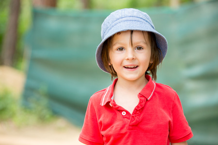 Portrait of a cute little boy in amusement park, having fun, summertimeの写真素材
