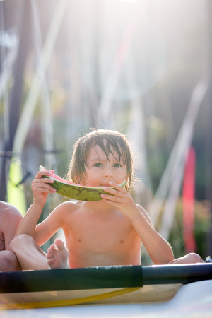 Cute little child, boy, eating watermelon on the beach, summertimeの写真素材