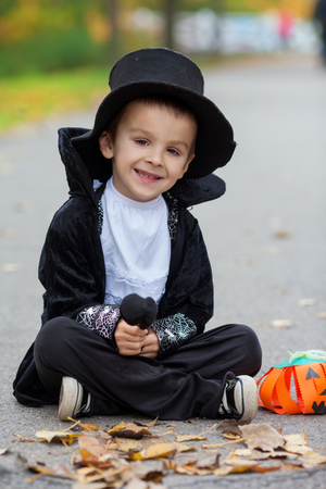 Cute boy in the park, wearing magician costume for Halloween, having funの写真素材