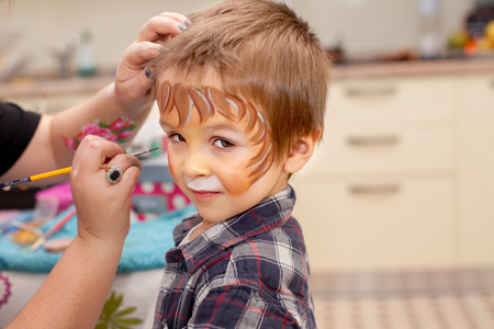Little boy with painted face as a lion, looking at cameraの写真素材