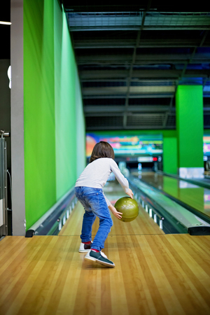 Young boy, playing bowling for the first time, indoorsの写真素材