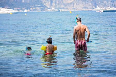 Father and two children, boys, preparing to go scuba diving on French Rivieraの写真素材