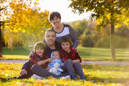 Three generation family playing in the park, having portrait autumn time. Family concept