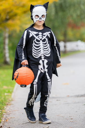 Cute child, boy dressed in halloween costume, playing in the park, autumn time, having funの写真素材