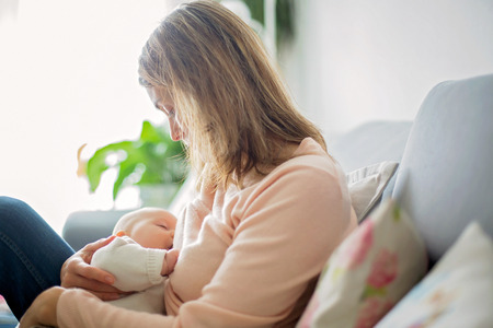 Young mother, holding tenderly her newborn baby boy, close portraitの写真素材