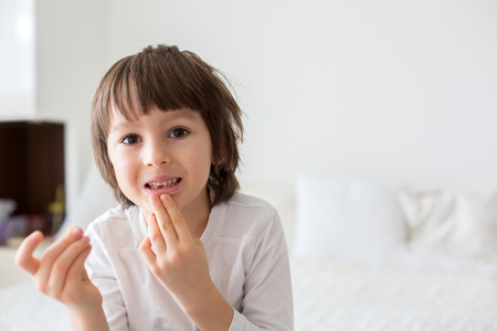 Little smiling child boy hand pointing his first baby milk or temporary tooth fall outの写真素材