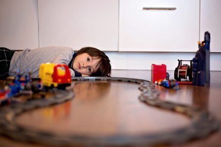Child boy playing in living room on the floor with a toy trainの写真素材