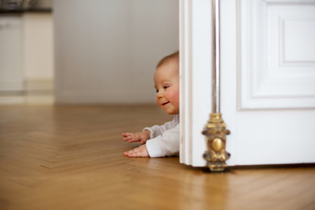 Little baby boy, toddler, in a long hall, crawling on the floor, smilingの写真素材