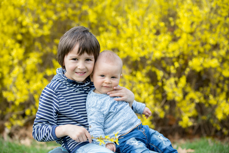 Adorable children, playing in the grass in park springtimeの写真素材