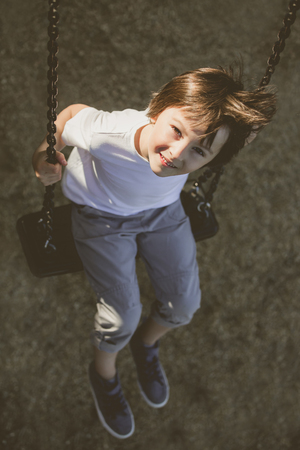 Child swinging on the playground  springtimeの写真素材