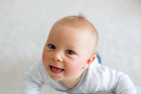 Portrait of cute little toddler child shot from above, baby boy smiling happilyの写真素材