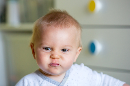 Image of sweet baby boy, closeup portrait of child, cute toddler with blue eyes, indoors shot