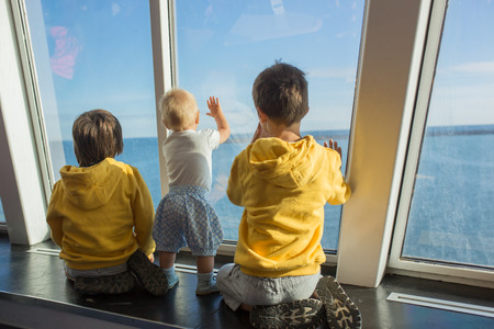 Beautiful children, on board on ferry boat, traveling for a vacation summertime