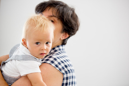 Grandmother holding happy baby at home, in living room