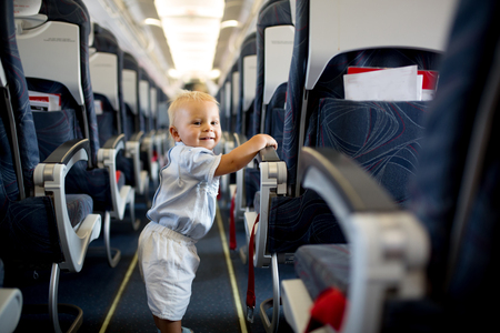 Little baby boy, playing with toys on board of the aircraft, happy travelerの写真素材
