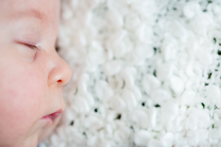 Beautiful newborn baby boy, sleeping with little toyの写真素材