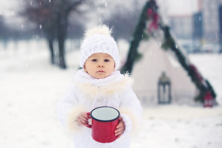 Happy family with kids, having fun outdoor in the snow on Christmas, playing with sledge, teepee and christmas decorationの写真素材