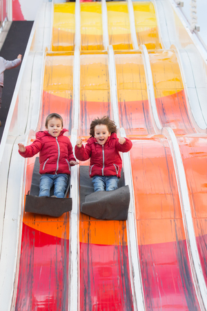 Happy children, going down huge slide, happy, enjoying the rideの写真素材