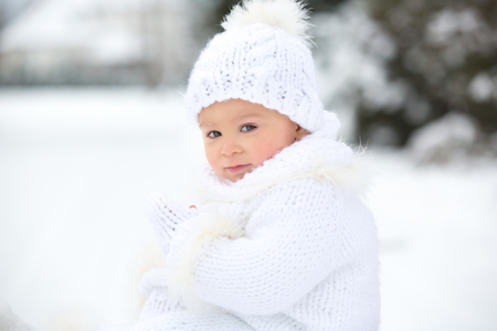 Cute little toddler boy, playing outdoors with snow on a winter day, snowingの写真素材
