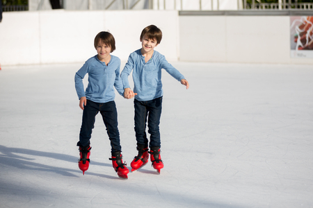 Happy boy with hat and jacket, skating during the day, having fun outdoors, winter time on Christmasの写真素材