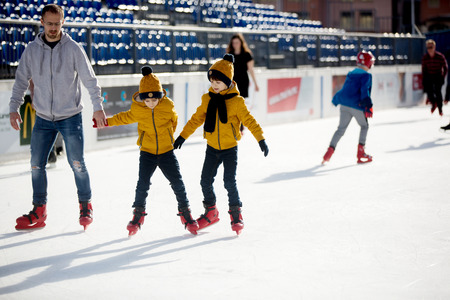 Happy boy with hat and jacket, skating during the day, having fun outdoors, winter time on Christmasの写真素材