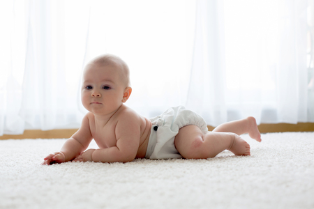 Cute little smiling newborn baby boy, playing in the morning, baby activity